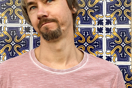 Man standing against decorative tiled wall in Lisbon