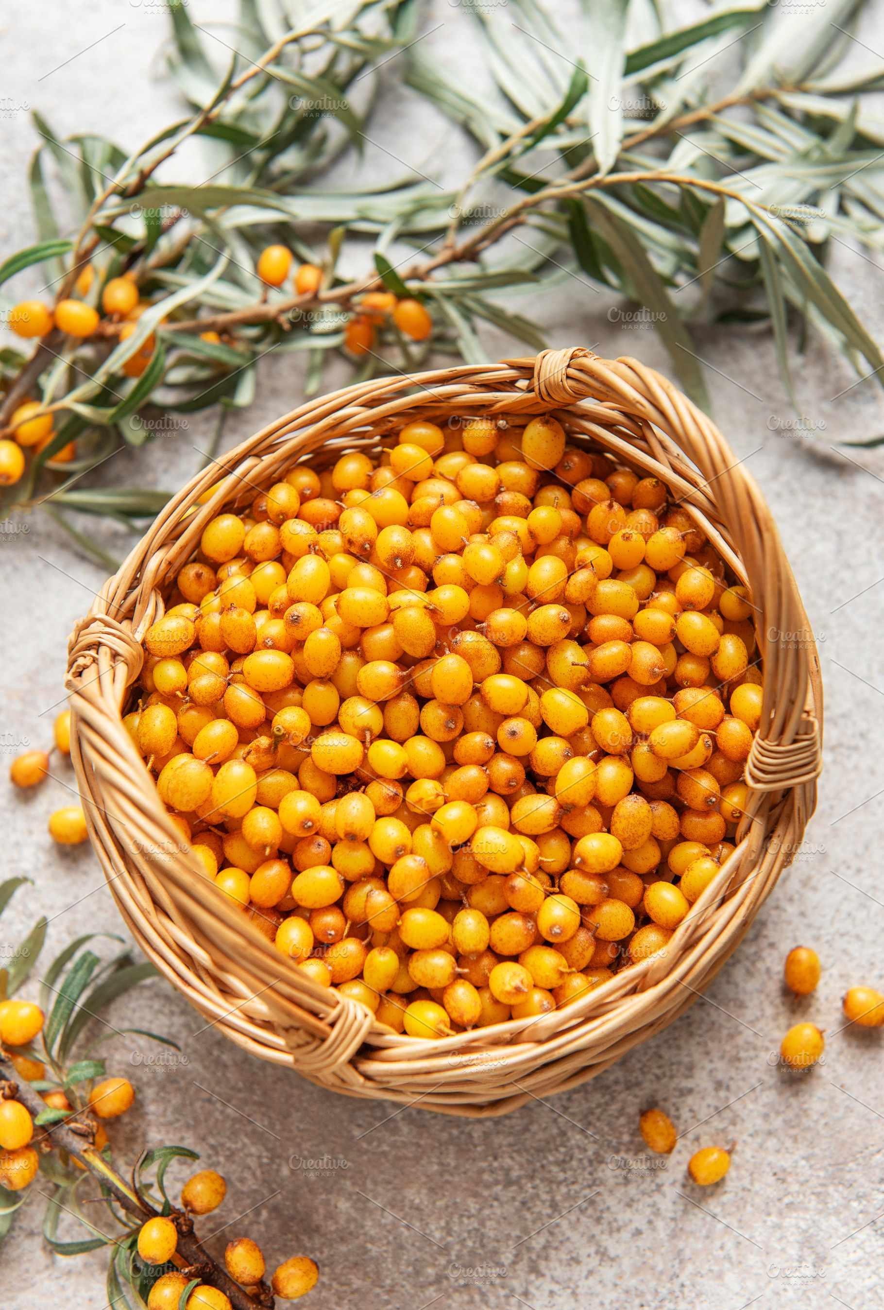 Fresh sea buckthorn berries overflowing a small wicker basket, a Food & Drink Photo by Olena Rudo