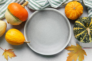 Empty plate surrounded by autumn gourds and leaves, a Food & Drink Photo by Olena Rudo