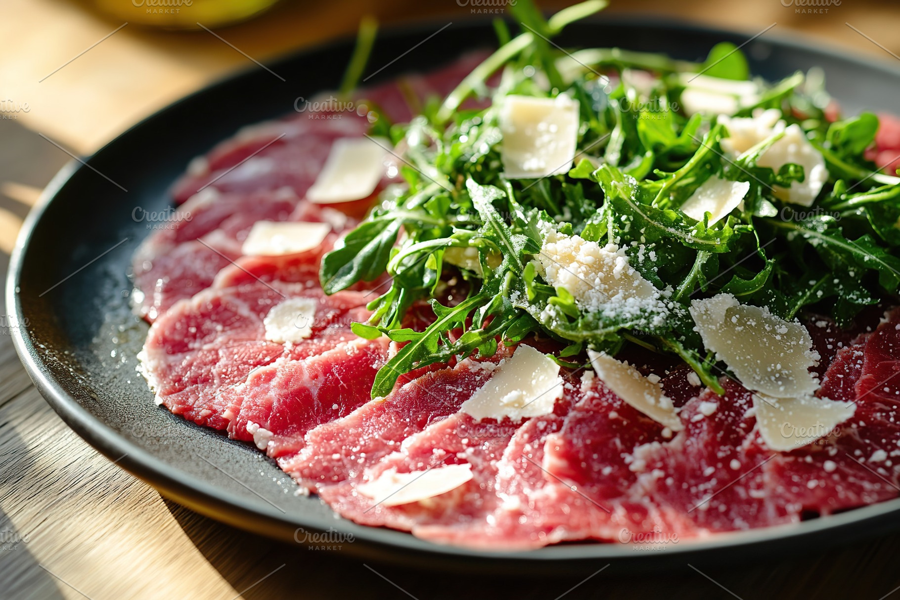 Beef carpaccio topped with fresh arugula and shaved cheese on a black plate, a Food & Drink Photo by AlyaAnd