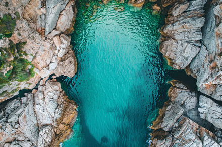 Clear turquoise water flows between, a Photo by Tanuart