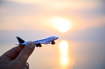 toy plane in hand against the backdrop of a beautiful sea sunset, a Transportation Photo by TanaCh