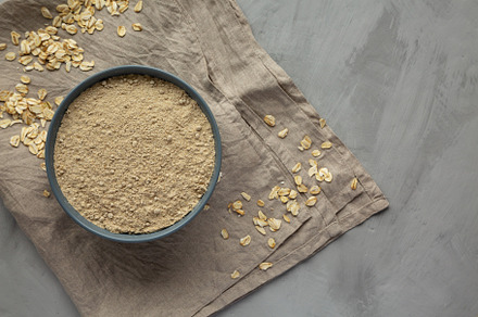 Organic White Oat Flour in a Bowl on a gray background, top view, a Food & Drink Photo by LiudmylaChuhunova