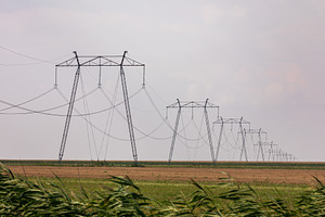 Row of high voltage power lines stretching across an open rural landscape under, a Technology Photo by Ales Munt