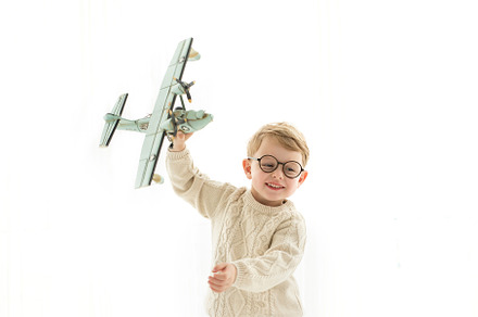 boy playing with airplane over white