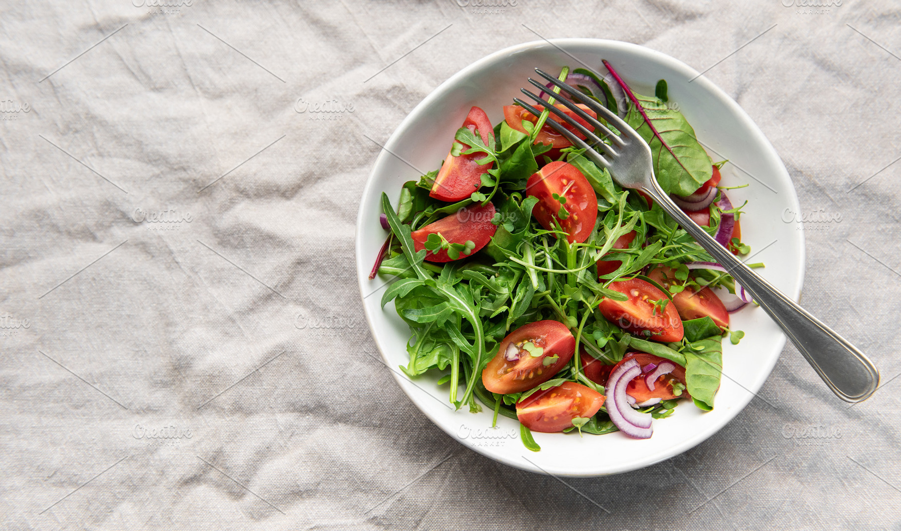 Fresh garden salad with tomatoes, arugula, and onion, a Food & Drink Photo by Olena Rudo