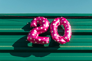 the number 20 displayed with pink balloons, a Photo by Nito