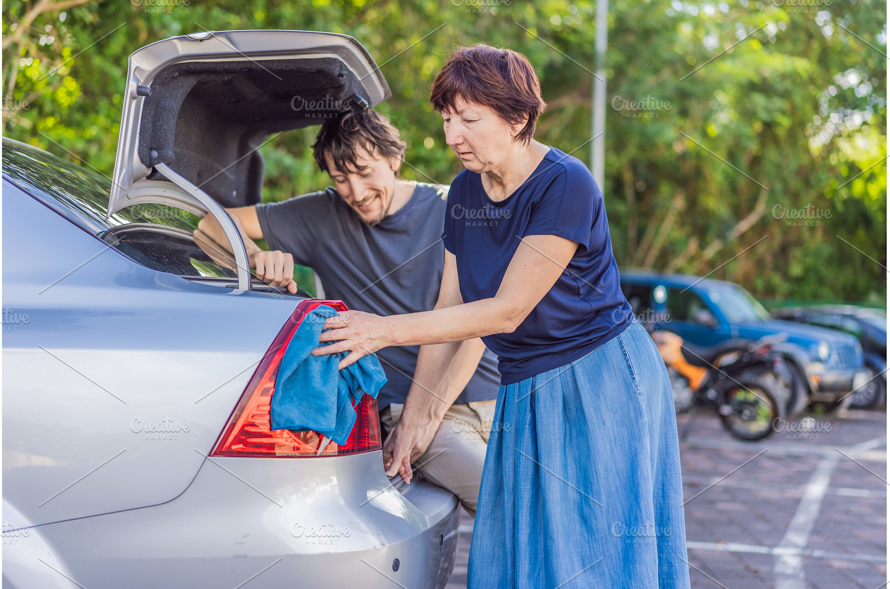 Older woman washing a car together, a Person Photo by Elizaveta Galitskaya