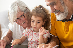 Grandparents helping granddaughters with drawing and homework, a Person Photo by etorres69