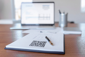 Desk showing a printed QR code on a paper document, a Business Photo by DanFLCreativo