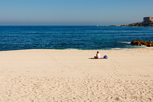Rear view of a woman relaxing on a sandy beach in La Coruña dur, a Person Photo by Bepslabor