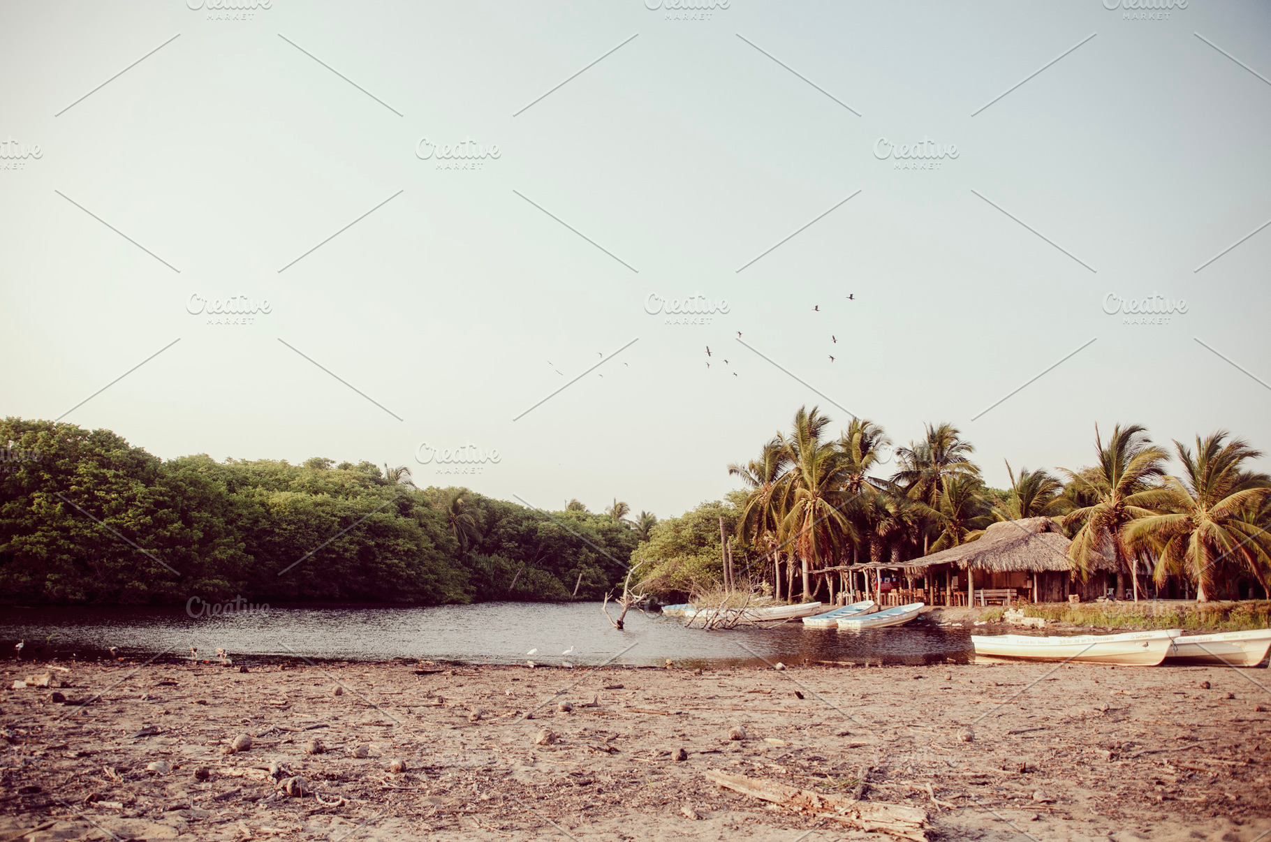 Golden lagune with cabañas and boats, a Nature Photo by MUSTERIUM