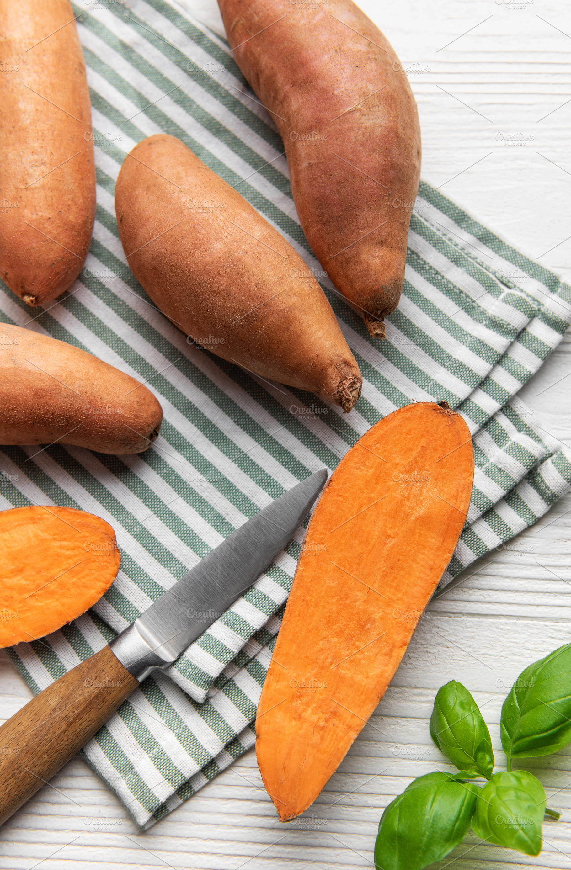 Cutting sweet potatoes for healthy plant based cooking, a Food & Drink Photo by Olena Rudo