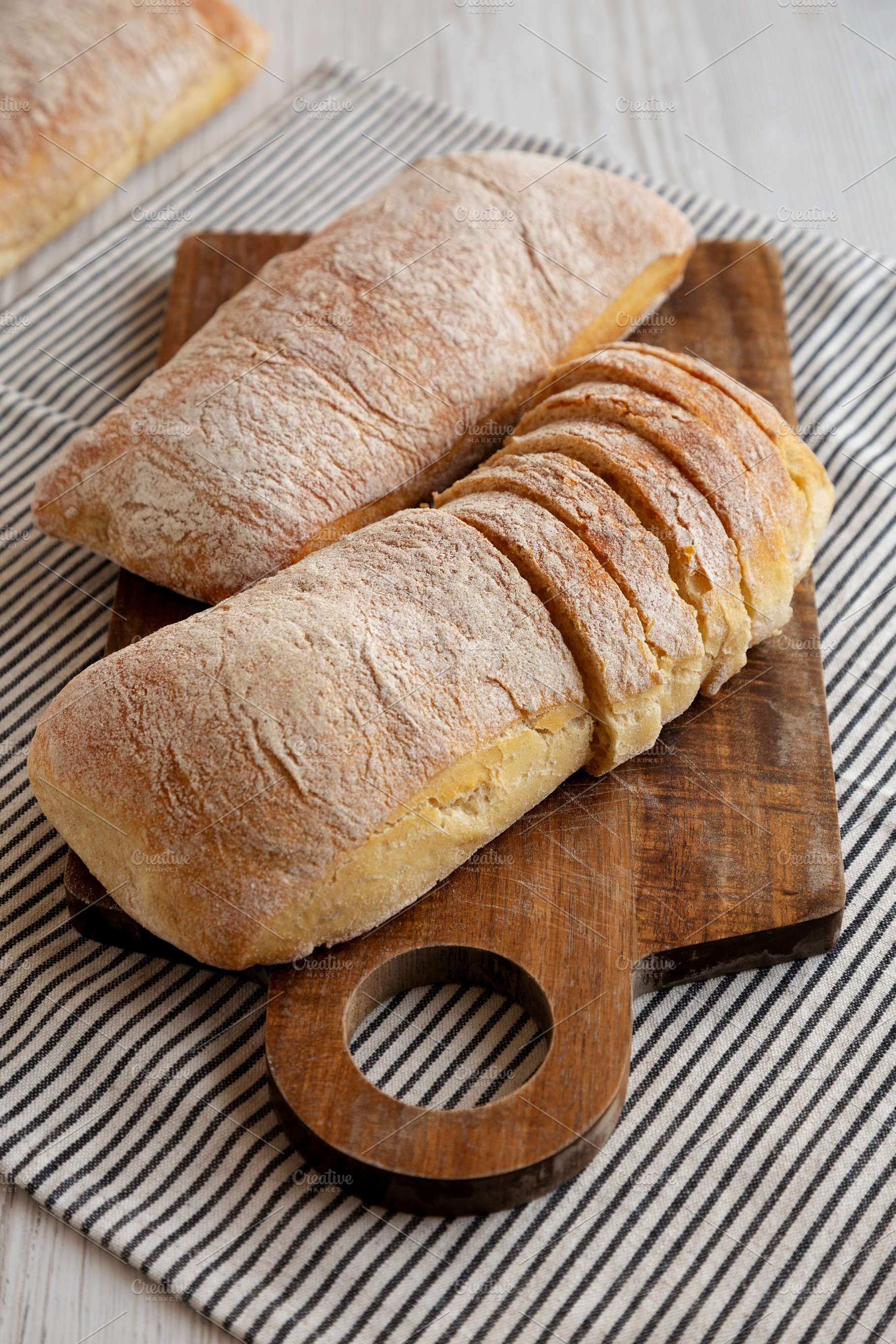Homemade Ciabatta Bread on a wooden board, side view., a Food & Drink Photo by LiudmylaChuhunova