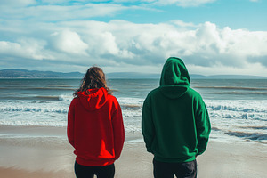 Man & woman in red and green hoodies, a Photo by Pavel_design
