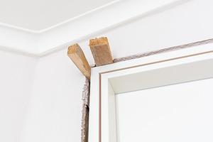 Construction worker installing new interior door frame, an Architecture Photo by Antonio Gravante Market