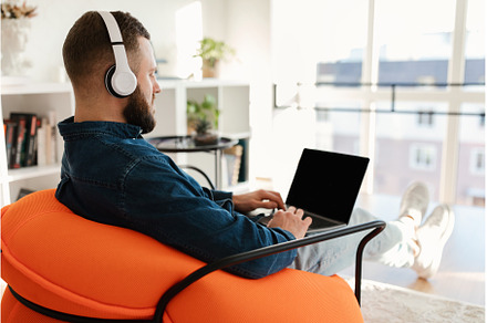 Millennial Guy Using Laptop With, a Person Photo by Prostock-Studio