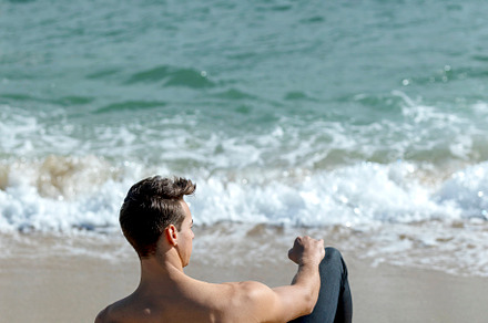Rear view of a young bared man weari