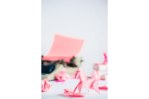 Pink origami unicorn with crumpled containing typewriter, writing, and pink