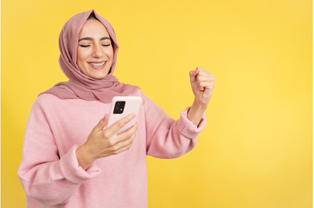 Excited muslim woman celebrating, a Person Photo by Iván Moreno STOCK PHOTO