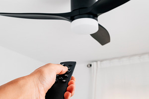 ceiling fan controlled by a man using a remote, a Photo by Nito
