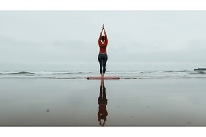 A woman practices yoga on a beach, a Sports & Recreation Photo by Sergey Kotenev