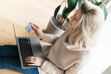 Young woman holding credit card and using laptop computer., a Business Photo by Olena Rudo