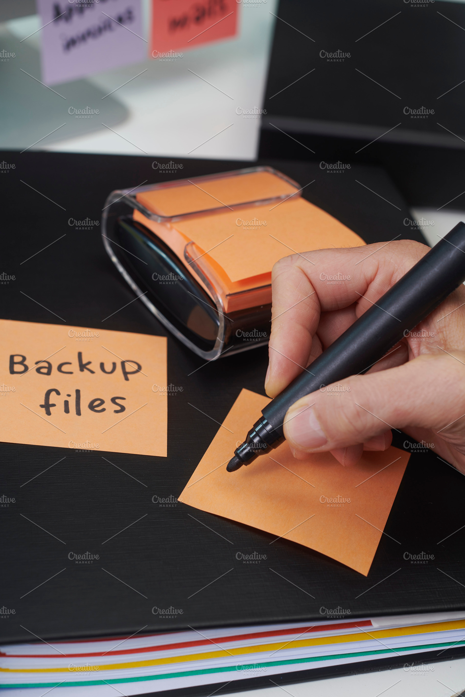 orange sticky note about to be written by a man, a Photo by Nito