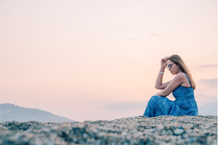 Woman sits on the beach and looks at, a Person Photo by Jan Jack Russo Media