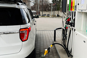 White SUV Refueling at a Gas Station with a Green Fuel Can, a Photo by AS photostudio