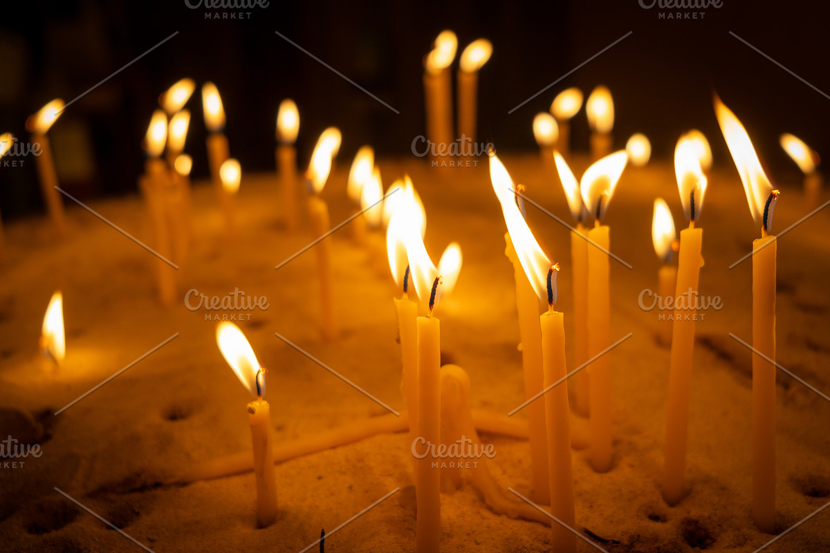 Burning candles with warm flames placed in a bed of sand, an Abstract Photo by GoodGoods (Photo 1 of 2)