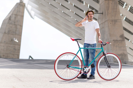 young man using his cellphone while going to work with his bicycle