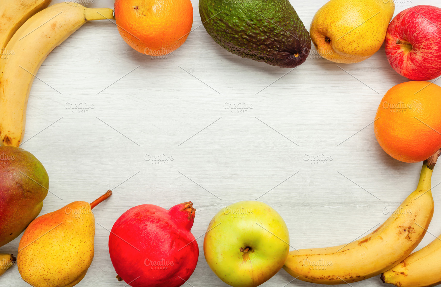 Frame of fresh fruit creating empty space on white wooden table, a Food & Drink Photo by Antonio Gravante Market