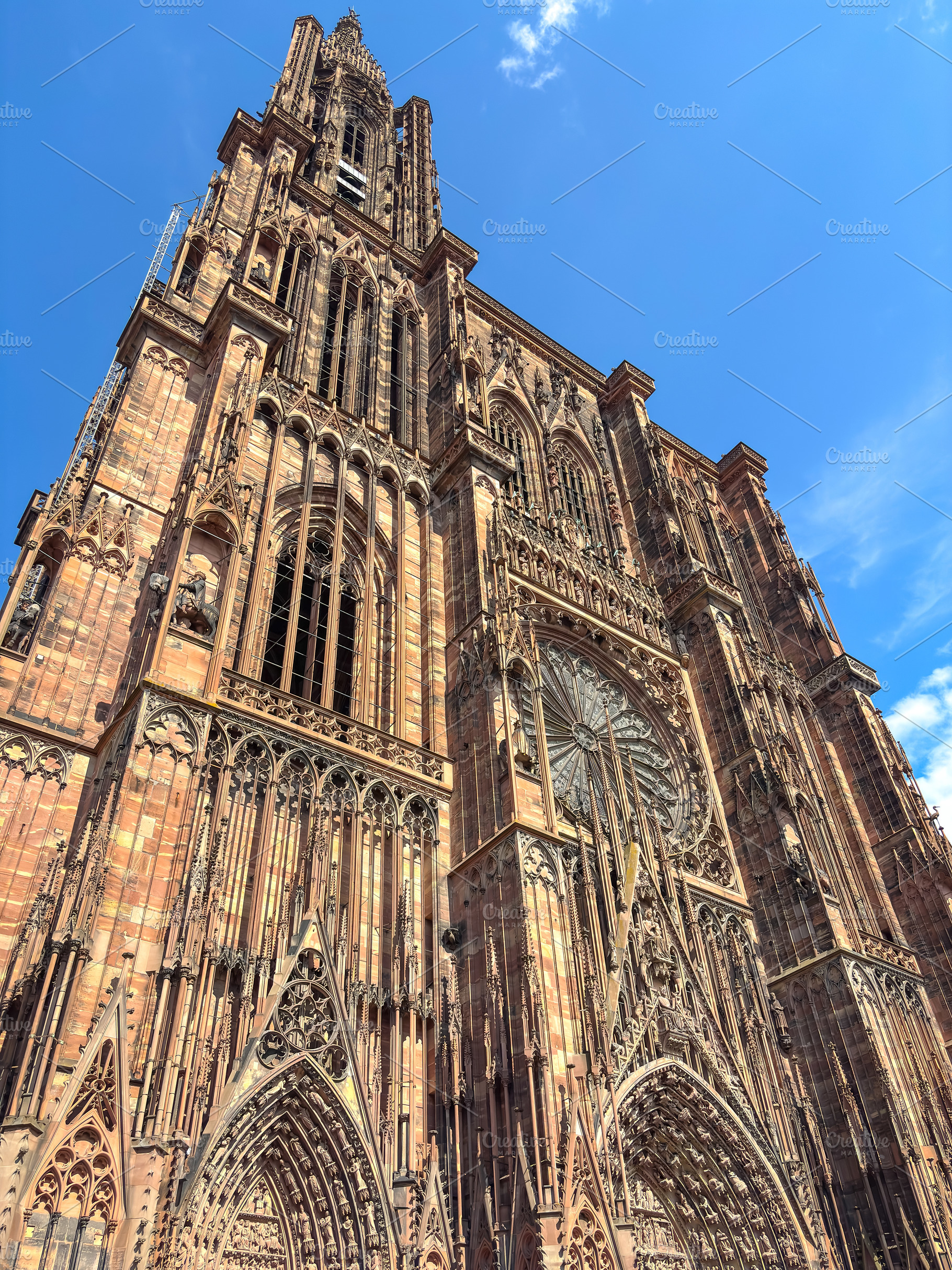 Strasbourg Cathedral facade under bright blue summer sky, an Architecture Photo by GoodGoods