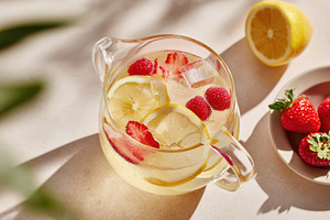 Lemon and strawberry infused water in glass pitcher, a Food & Drink Photo by AlyaAnd