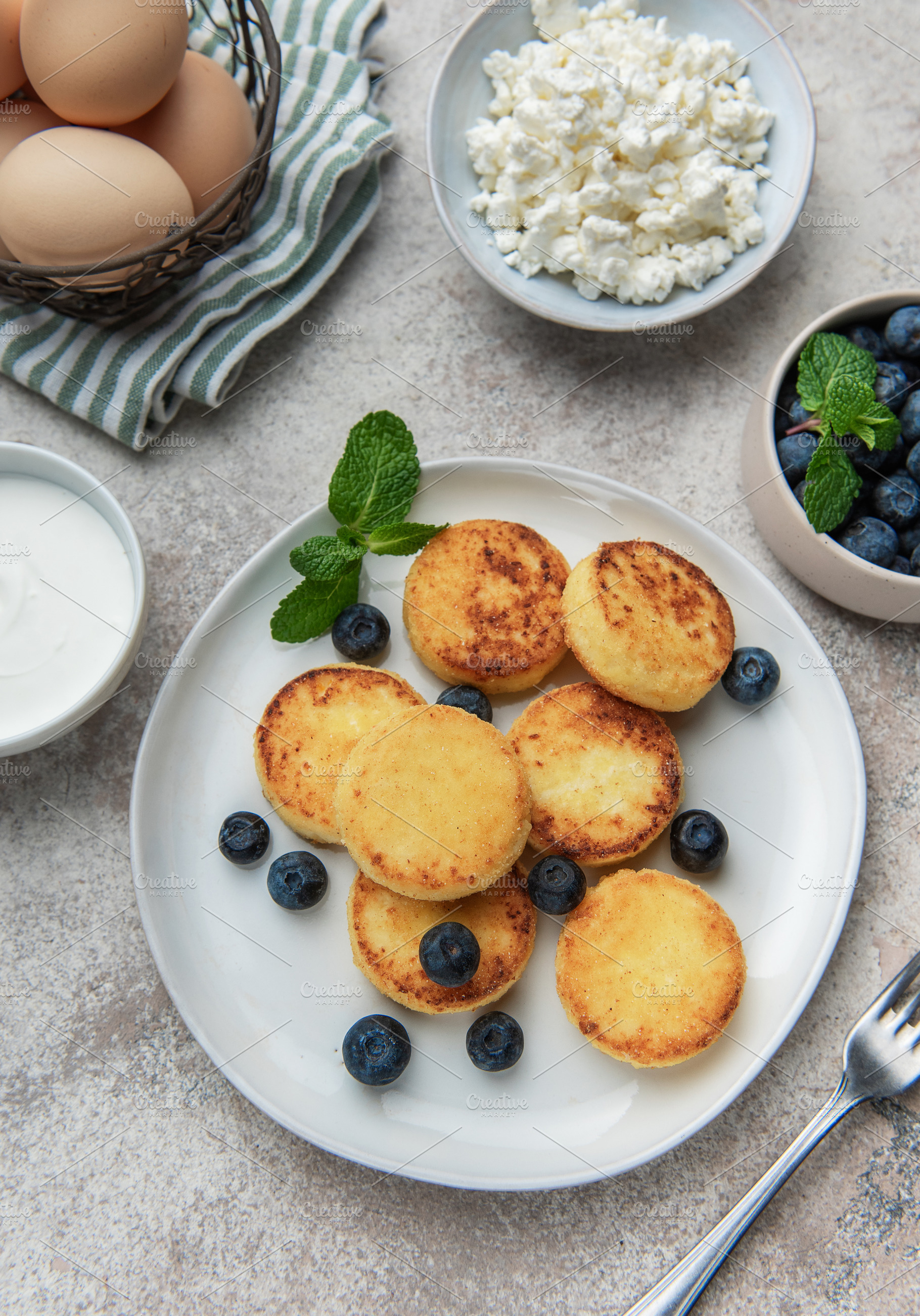 Syrniki cottage cheese pancakes with fresh blueberries and mint, a Food & Drink Photo by Olena Rudo