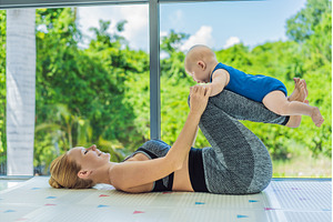Mother doing fitness exercises while, a Person Photo by Elizaveta Galitskaya