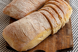 Homemade Ciabatta Bread on a wooden board, side view., a Food & Drink Photo by LiudmylaChuhunova