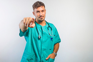 Confident Doctor Pointing Straight at Camera, a Person Photo by karrastock