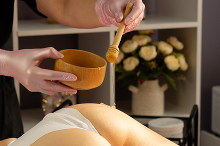 Beautician applying honey treatment
