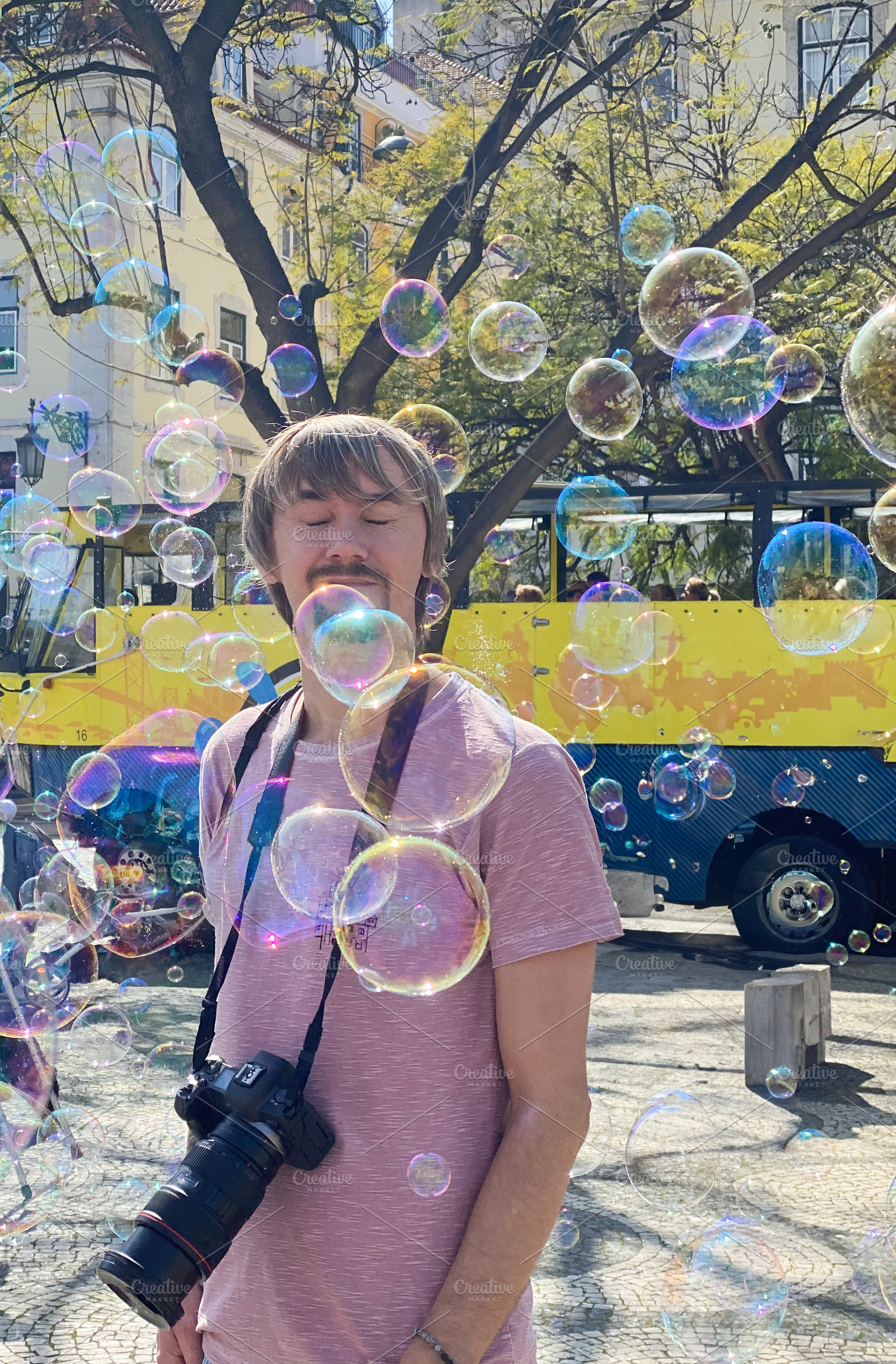 A man enjoying soap bubbles in bright sunlight, a Person Photo by sebastianaraw