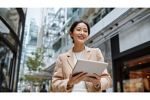 Asian businesswoman holding a tablet, a Person Photo by Sergey Kotenev