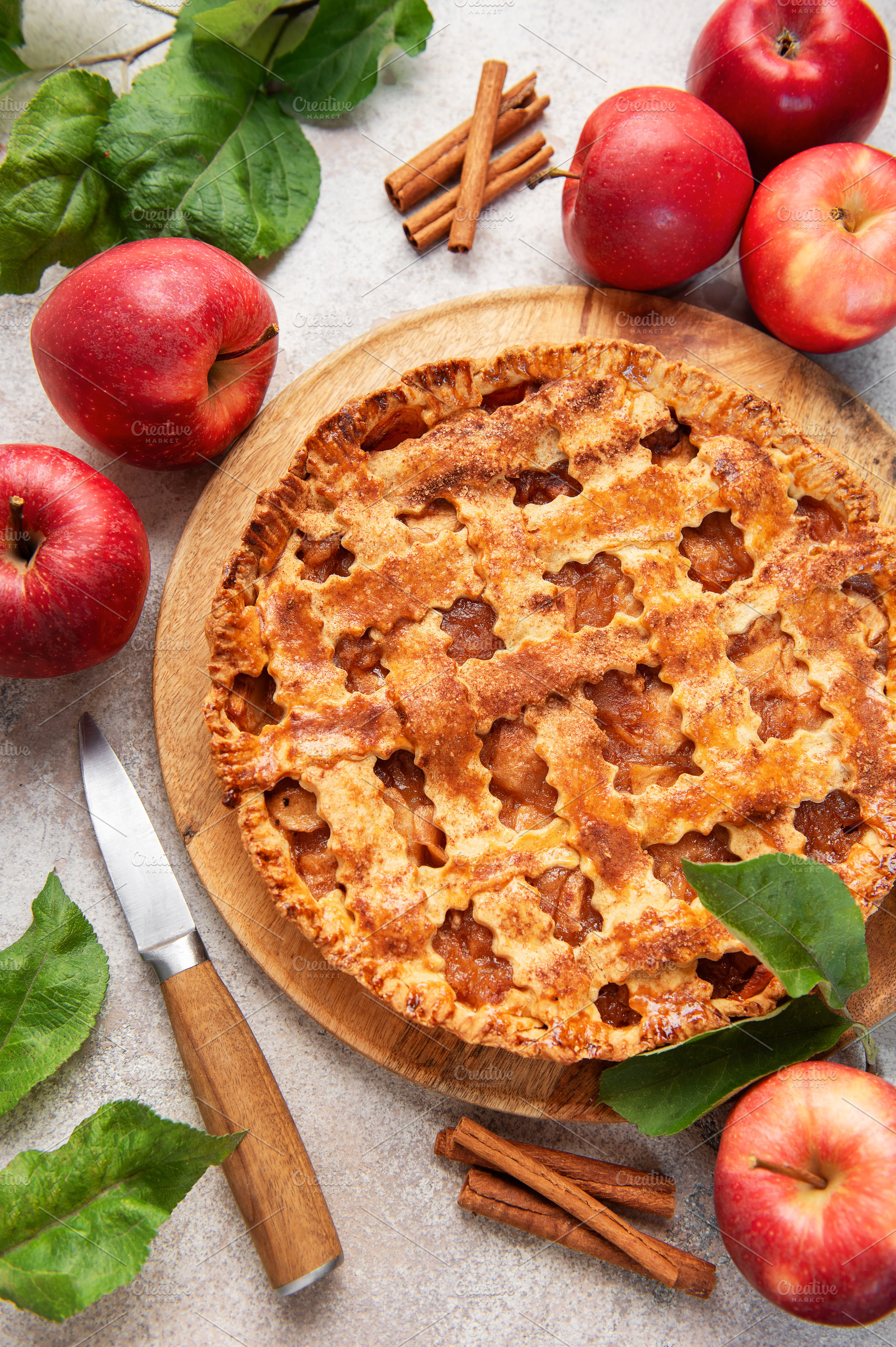 Freshly baked apple pie decorated with cinnamon sticks and apple, a Food & Drink Photo by Olena Rudo