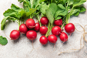 Fresh radishes with green leaves on grey background, a Food & Drink Photo by Olena Rudo