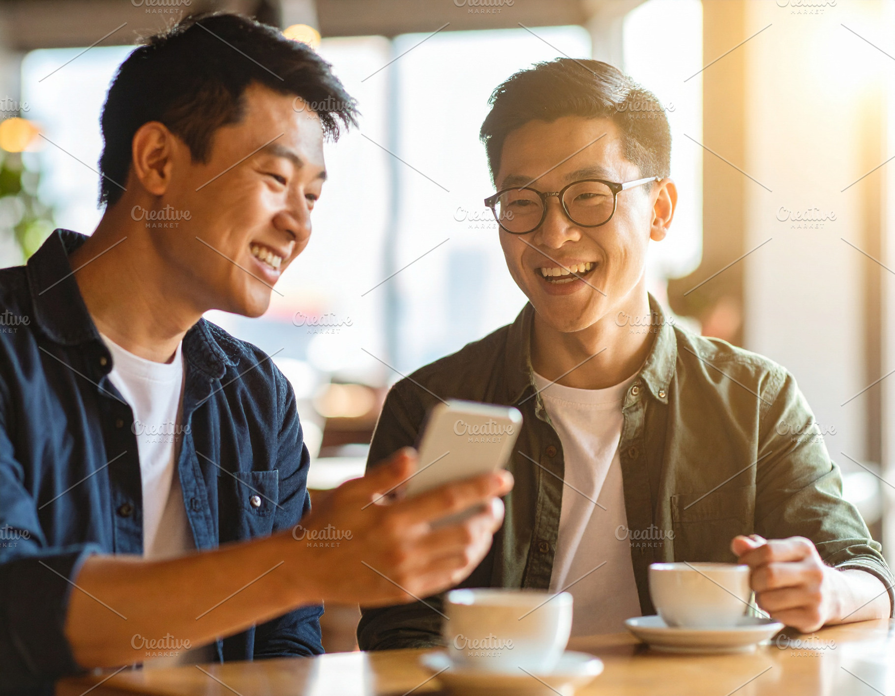 Smiling men sharing phone moment at coffee shop, a Person Photo by DanFLCreativo