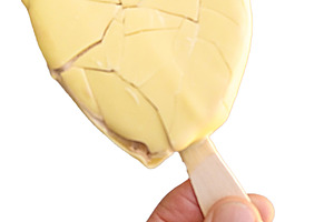 Hand holding heart-shaped lollipop ice cream on street, a Food & Drink Photo by DanFLCreativo