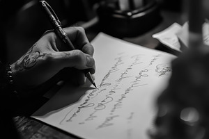 Close up of a hand writing a letter, a Photo by Iftikhar Alam