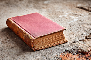 Weathered book resting on a rough surface in an abandoned space on a quiet afte, a Photo by AlyaAnd
