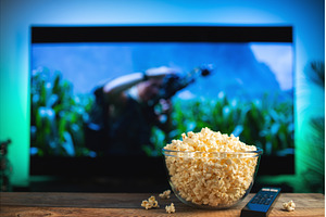 A glass bowl of popcorn and remote, a Technology Photo by Budarinphoto