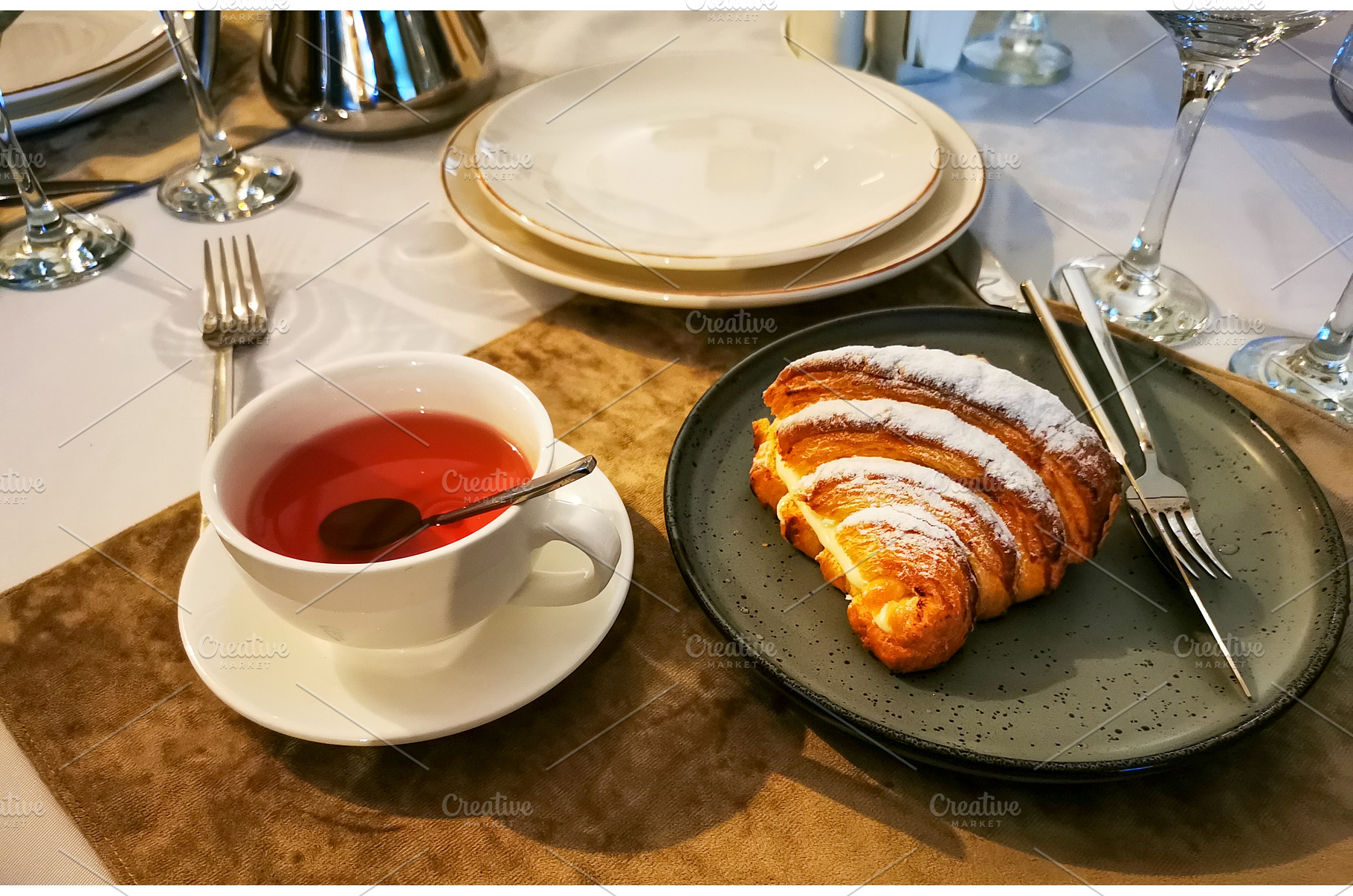 Croissant with custard, cup of tea, a Food & Drink Photo by sceptical cactus